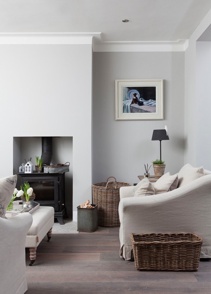 Inspiration for a scandinavian enclosed living room in Dublin with white walls, dark hardwood floors, a metal fireplace surround and brown floor.