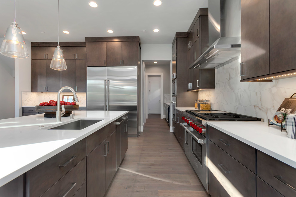 Inspiration for a large contemporary single-wall eat-in kitchen in Seattle with an undermount sink, flat-panel cabinets, dark wood cabinets, quartz benchtops, white splashback, stainless steel appliances, medium hardwood floors, with island and grey floor.