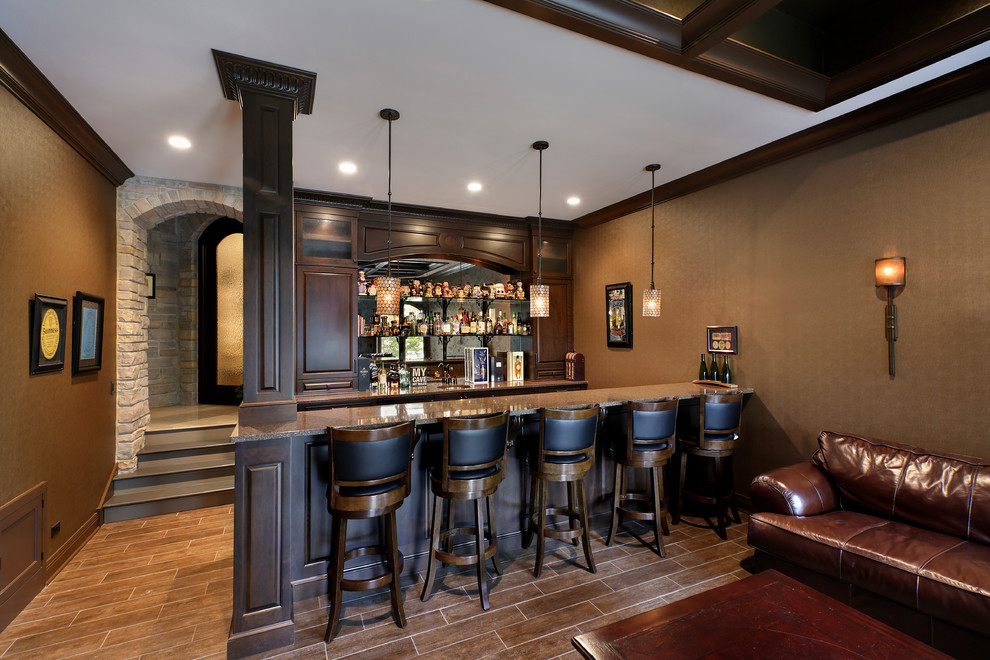 Design ideas for a traditional seated home bar in Chicago with raised-panel cabinets, dark wood cabinets and mirror splashback.