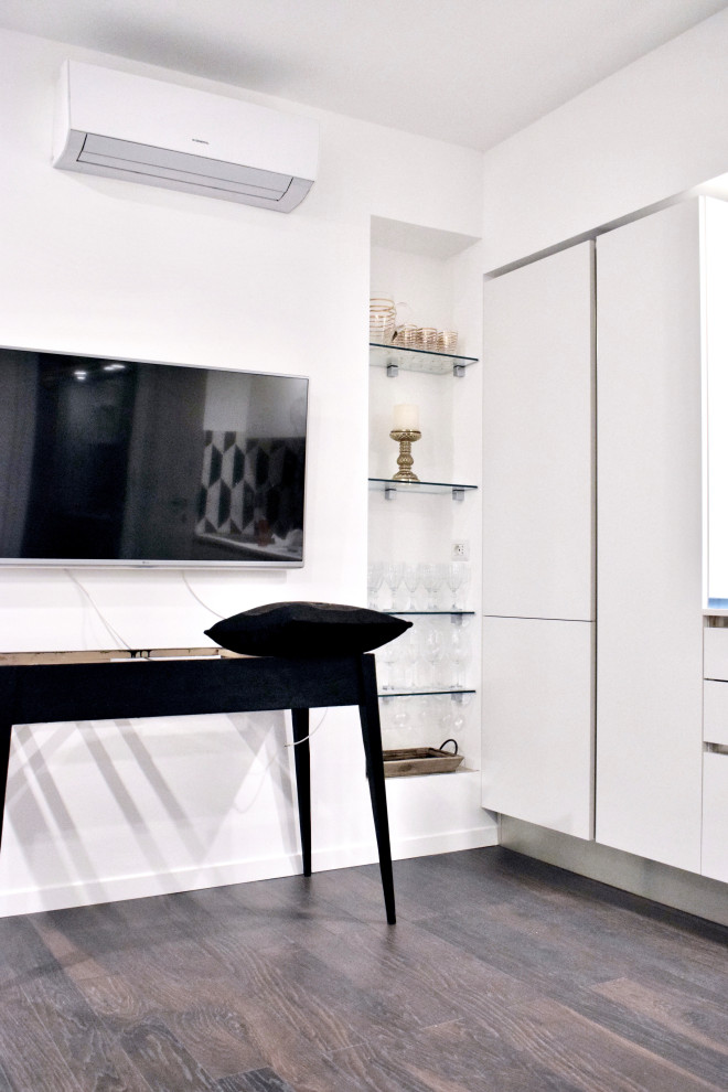 Идея дизайна: двухуровневая гостиная комната в стиле модернизм с белыми стенами, полом из ламината и телевизором на стене