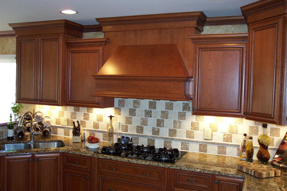 Inspiration for a transitional l-shaped porcelain tile kitchen pantry remodel with a double-bowl sink, recessed-panel cabinets, medium tone wood cabinets, granite countertops, beige backsplash, stone tile backsplash, stainless steel appliances and no island