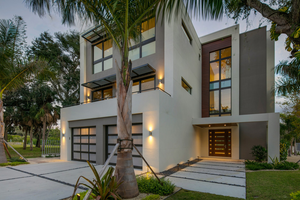 This is an example of a mid-sized contemporary three-storey stucco white house exterior in Tampa with a flat roof.