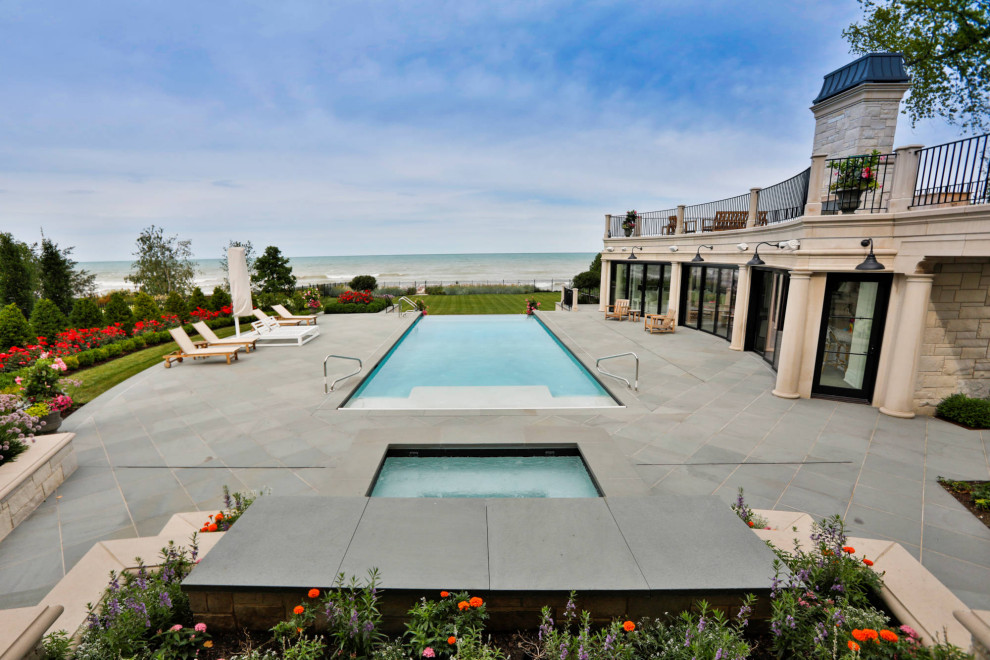 This is an example of a mid-sized traditional courtyard rectangular lap pool in Chicago with with a pool and natural stone pavers.