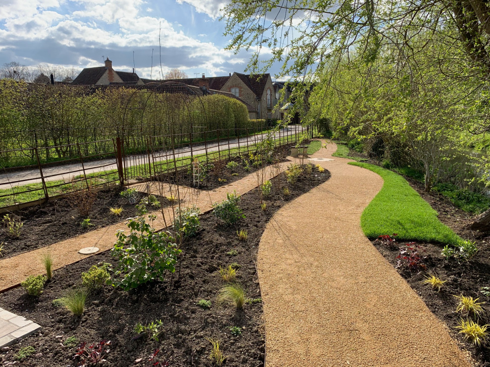 Inspiration pour un grand jardin à la française latéral traditionnel l'été avec un chemin, une exposition partiellement ombragée, du gravier et une clôture en métal.