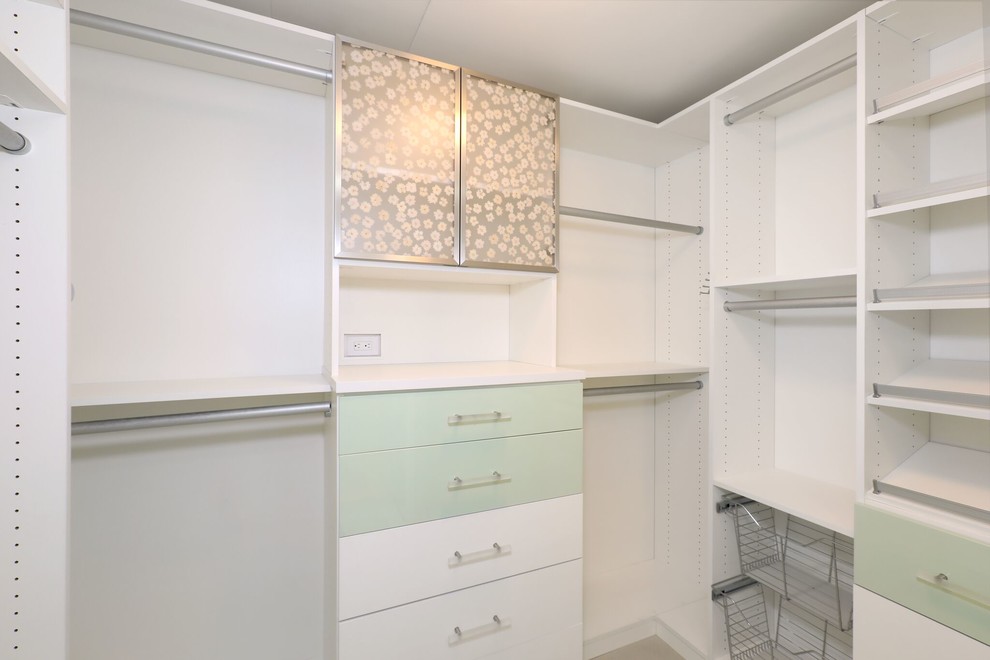 Photo of a mid-sized contemporary walk-in wardrobe in Orange County with flat-panel cabinets, green cabinets, light hardwood floors and brown floor.