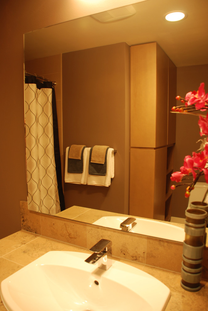 Inspiration for a transitional bathroom in Seattle with a drop-in sink, flat-panel cabinets, light wood cabinets, tile benchtops, a freestanding tub, a shower/bathtub combo, a one-piece toilet, beige tile, porcelain tile, brown walls and porcelain floors.