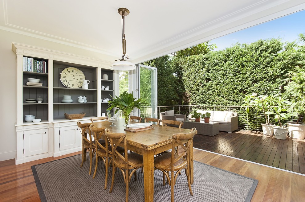 Transitional dining room in Sydney with white walls, medium hardwood floors and brown floor.