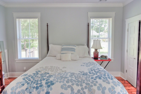 Mid-sized country guest bedroom in Atlanta with blue walls, medium hardwood floors and no fireplace.