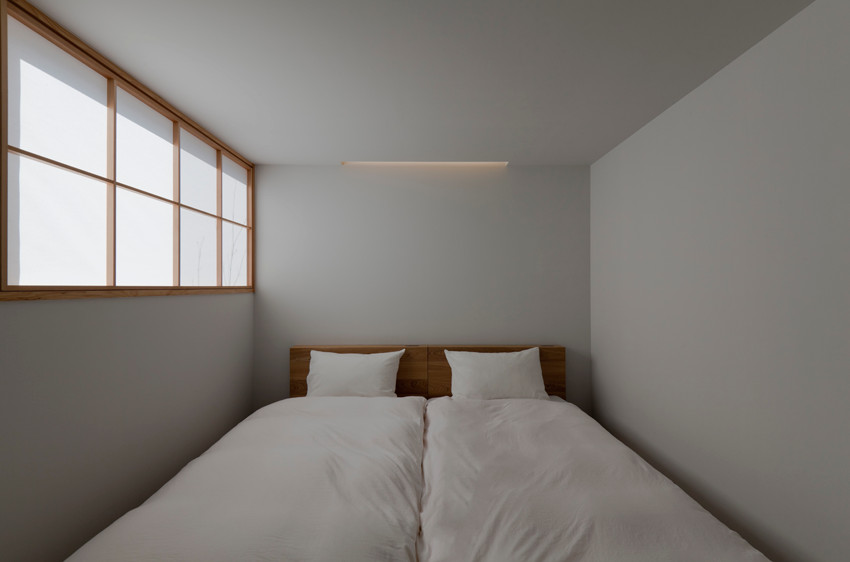 Kleines Hauptschlafzimmer mit weißer Wandfarbe, braunem Holzboden, Holzdielendecke und Holzdielenwänden in Fukuoka