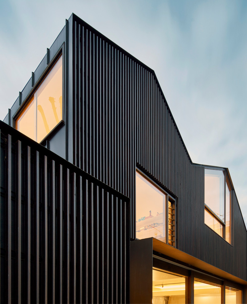 Inspiration for a large contemporary two-storey black house exterior in Melbourne with wood siding, a gable roof and a metal roof.