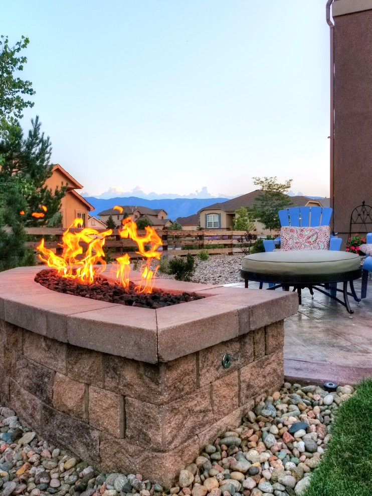 This is an example of a small eclectic patio in Denver with a fire feature, stamped concrete and no cover.