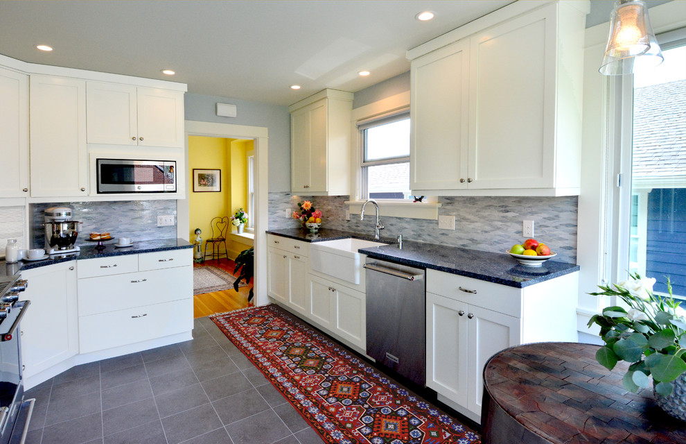 This is an example of a mid-sized transitional l-shaped separate kitchen in Seattle with a farmhouse sink, shaker cabinets, white cabinets, quartz benchtops, grey splashback, glass tile splashback, stainless steel appliances, porcelain floors, no island, grey floor and multi-coloured benchtop.