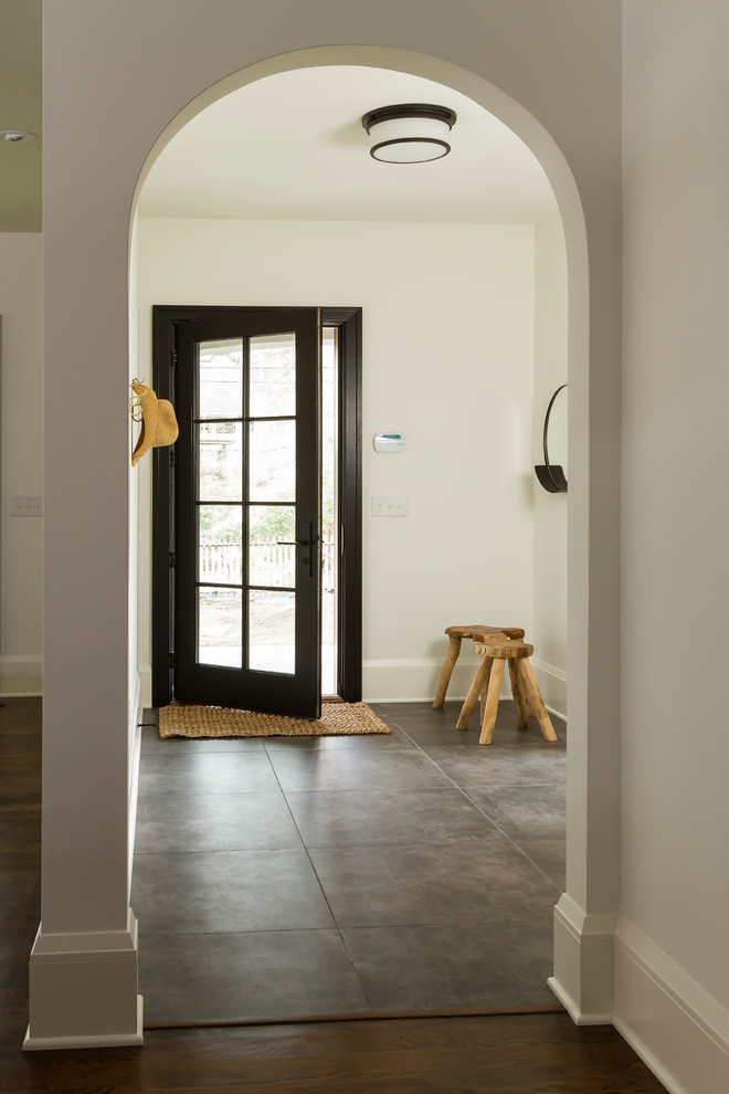 Design ideas for a mid-sized transitional mudroom in Minneapolis with white walls, a single front door, a black front door, grey floor and porcelain floors.