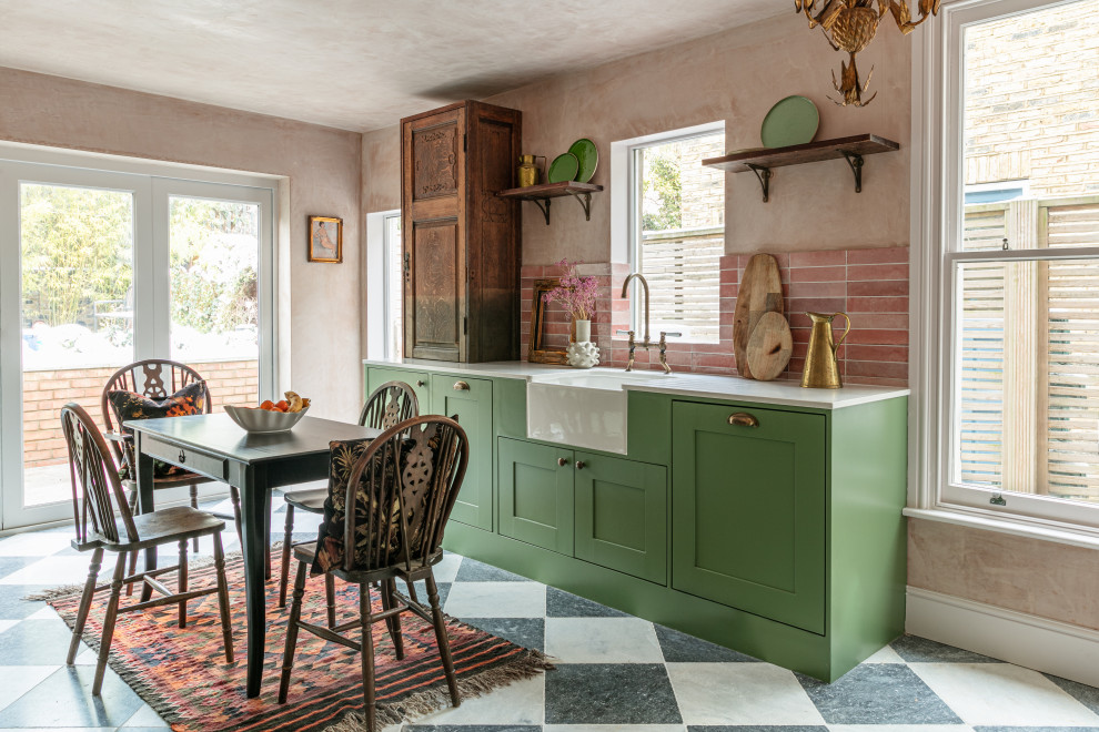 Photo of a mid-sized country galley eat-in kitchen in London with a farmhouse sink, shaker cabinets, green cabinets, quartzite benchtops, pink splashback, ceramic splashback, no island, multi-coloured floor and white benchtop.