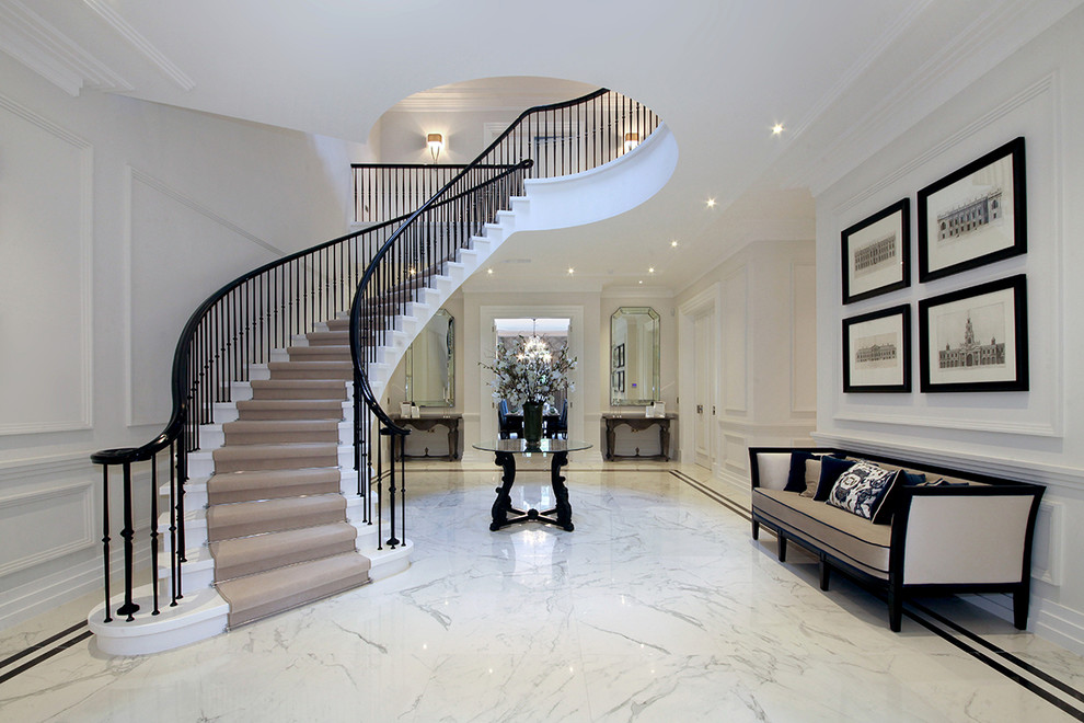 Design ideas for a large contemporary limestone curved staircase in Surrey with limestone risers and metal railing.