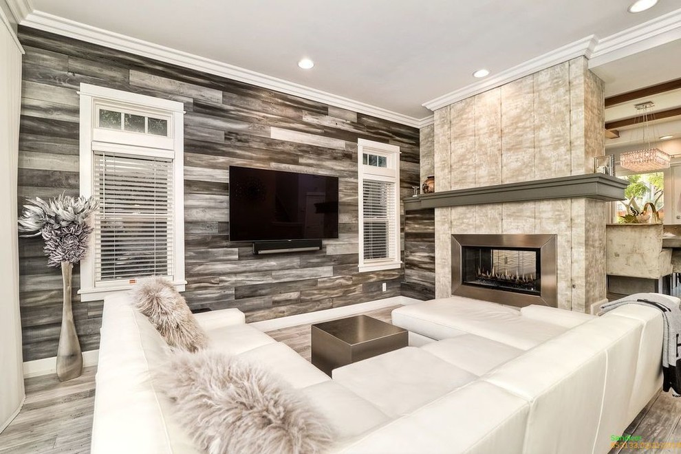 Inspiration for a large contemporary open concept living room in San Diego with grey walls, light hardwood floors, a two-sided fireplace, a concrete fireplace surround, a wall-mounted tv and grey floor.
