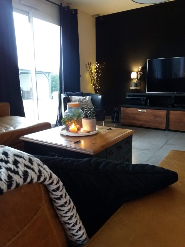 На фото: открытая гостиная комната среднего размера в стиле лофт с черными стенами, телевизором на стене, серым полом и деревянными стенами