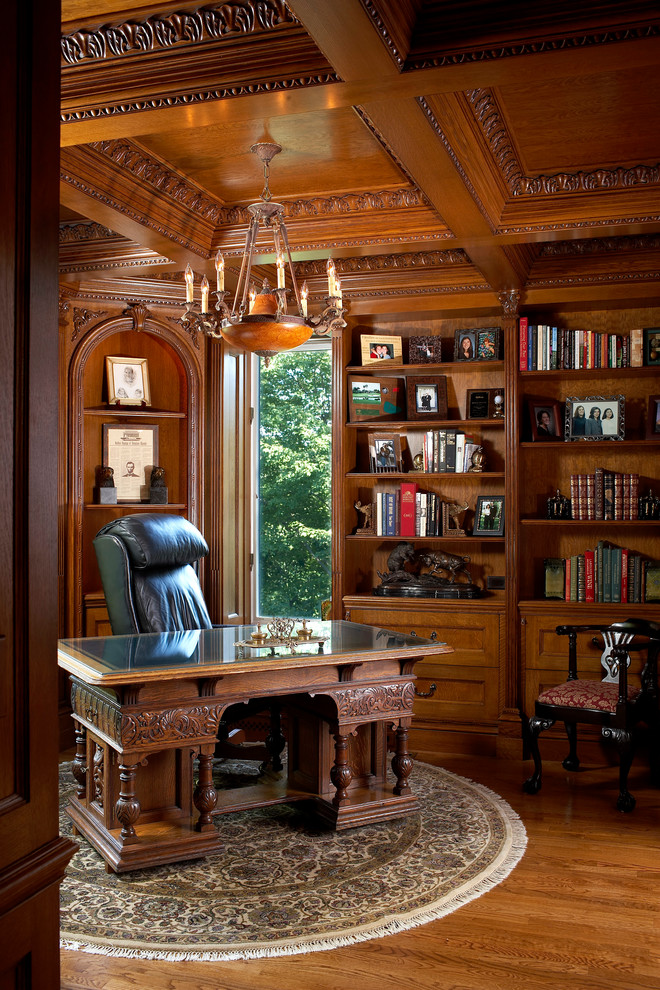 This is an example of a traditional home office in New York with medium hardwood floors and a freestanding desk.
