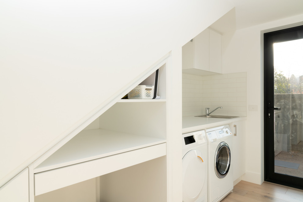 Design ideas for a contemporary single-wall utility room in Melbourne with flat-panel cabinets.