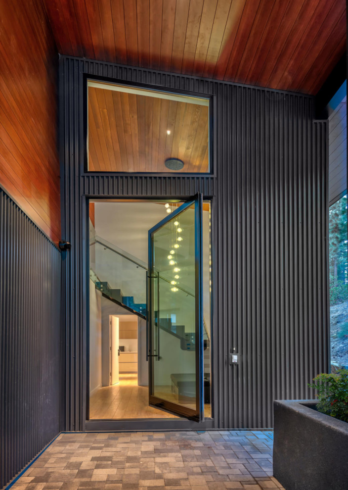 Immagine di una porta d'ingresso design con parquet chiaro, una porta a pivot, una porta nera, pavimento marrone, soffitto in legno e pareti in legno