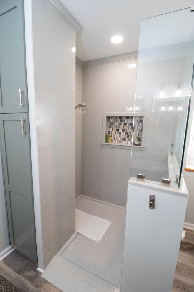 Design ideas for a mid-sized master bathroom in Other with shaker cabinets, green cabinets, an open shower, a two-piece toilet, grey walls, vinyl floors, an integrated sink, solid surface benchtops, brown floor, an open shower, grey benchtops, a double vanity and a built-in vanity.