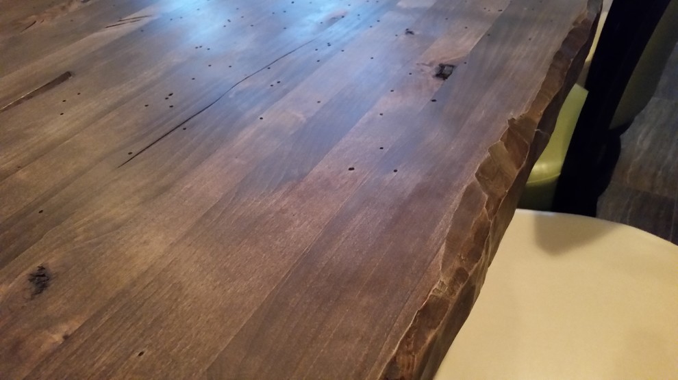 Large mountain style single-wall dark wood floor eat-in kitchen photo in Denver with raised-panel cabinets, distressed cabinets, an island, wood countertops, beige backsplash, wood backsplash and stainless steel appliances