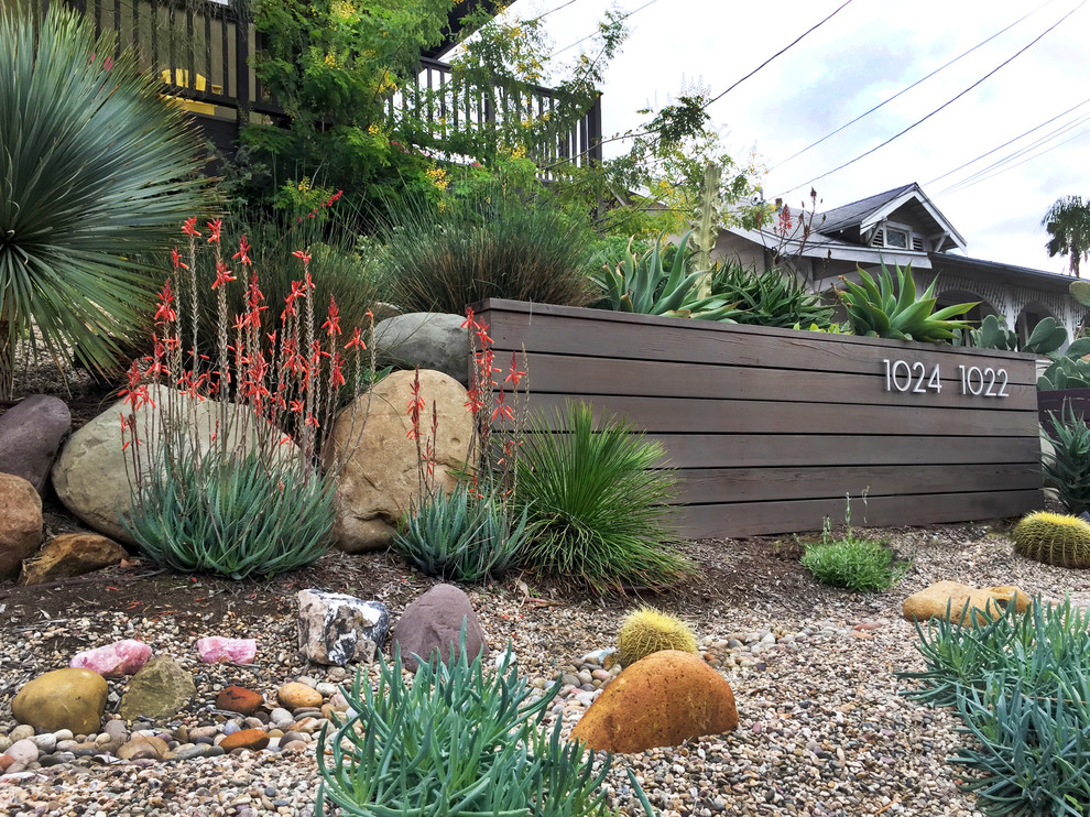 Photo of a small contemporary front yard full sun xeriscape in Los Angeles with a retaining wall.