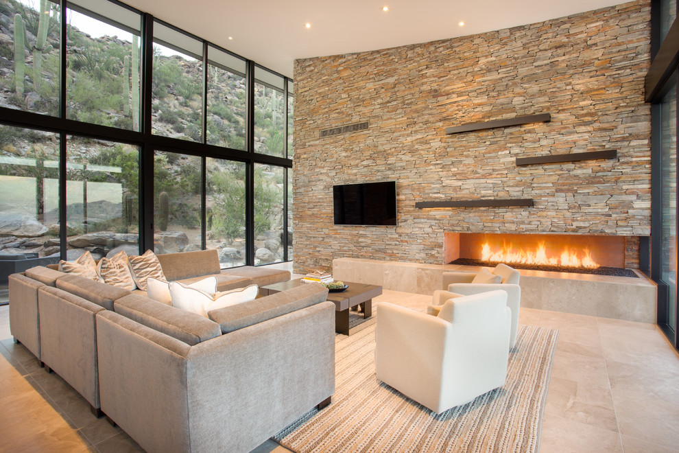 Inspiration for a large contemporary open concept living room in Phoenix with beige walls, limestone floors, a corner fireplace, a stone fireplace surround and a wall-mounted tv.