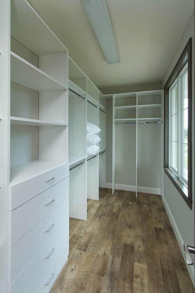 Inspiration for a mid-sized transitional gender-neutral walk-in wardrobe in Orlando with flat-panel cabinets and white cabinets.