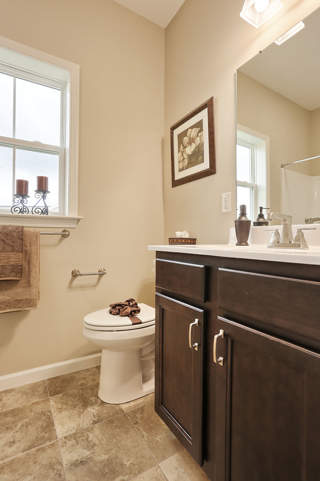 Photo of a large traditional 3/4 bathroom in Other with dark wood cabinets, an alcove shower, a two-piece toilet, beige walls, ceramic floors, an integrated sink, marble benchtops and a shower curtain.