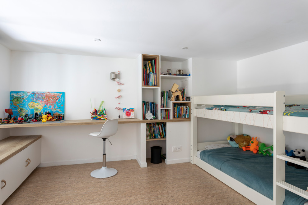 This is an example of a small modern children’s room for boys in Paris with white walls, cork flooring and brown floors.