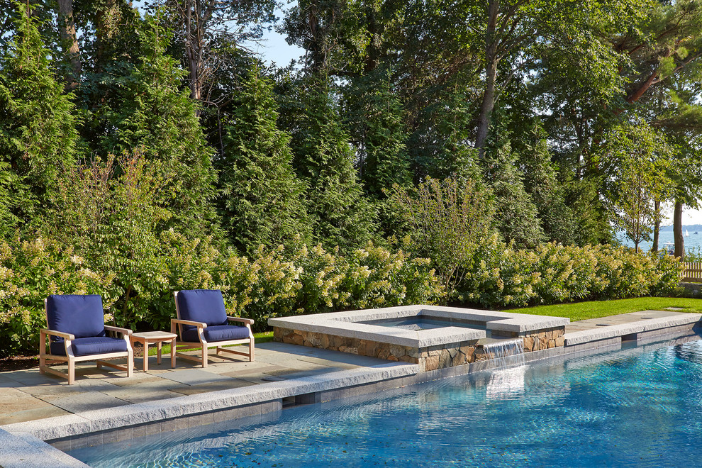 Mid-sized traditional side yard rectangular pool in Boston with a hot tub and natural stone pavers.