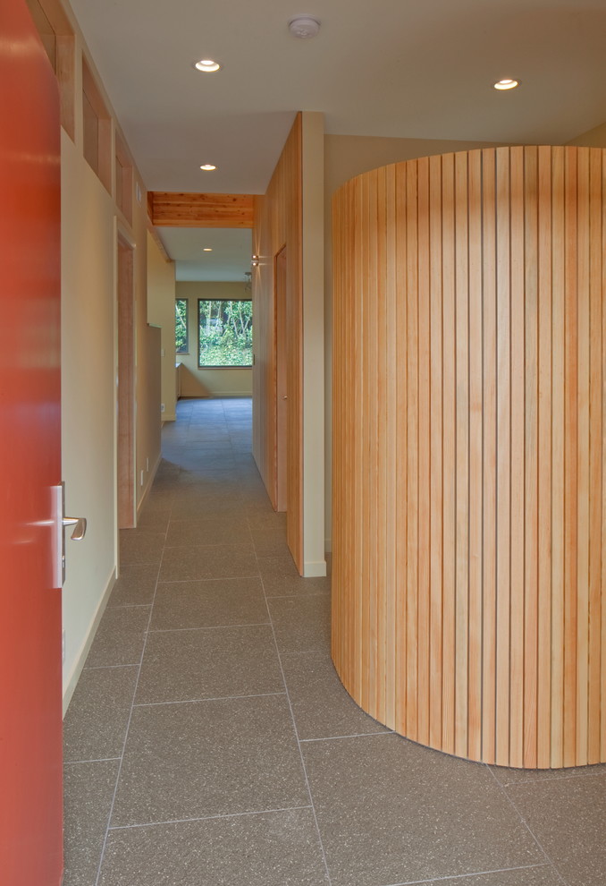 Photo of a mid-sized modern foyer in Portland with yellow walls, concrete floors, a single front door and a metal front door.