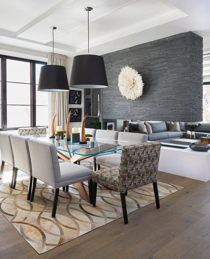 Design ideas for a mid-sized contemporary open plan dining in Toronto with white walls, medium hardwood floors, a two-sided fireplace, a stone fireplace surround and brown floor.