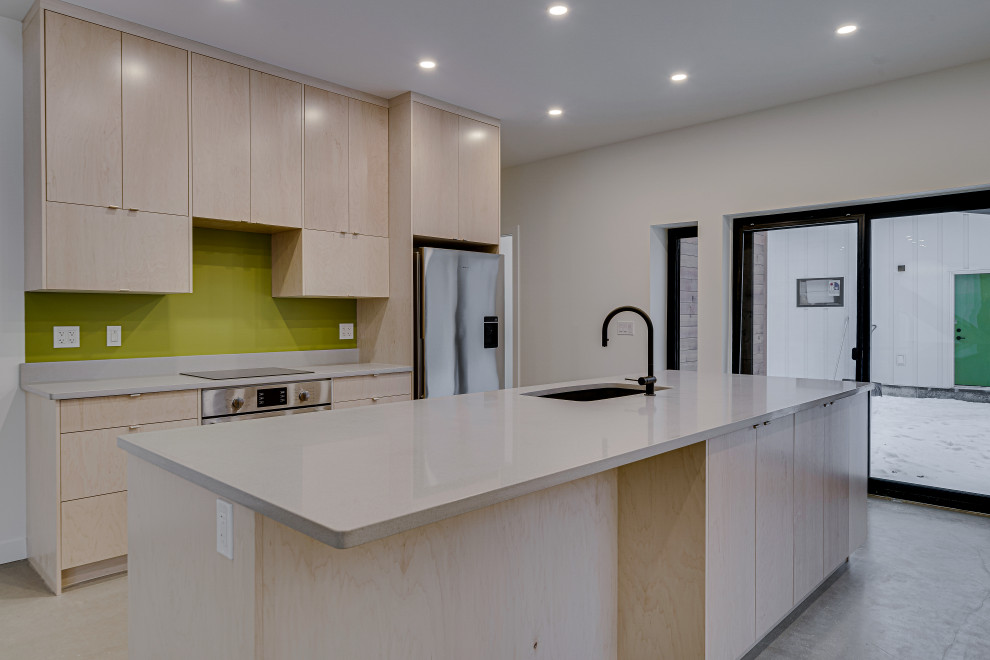 Photo of a mid-sized midcentury u-shaped eat-in kitchen in Other with an undermount sink, flat-panel cabinets, light wood cabinets, quartzite benchtops, green splashback, stainless steel appliances, concrete floors, with island, grey floor and white benchtop.