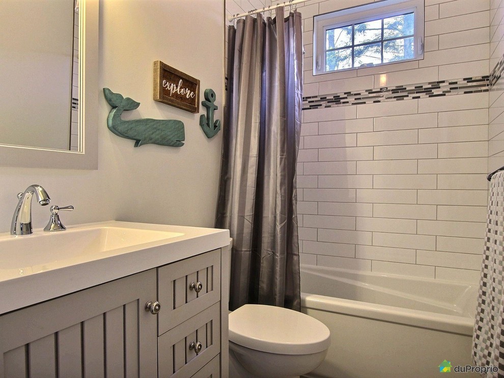 Design ideas for a small arts and crafts kids bathroom in Montreal with shaker cabinets, grey cabinets, a drop-in tub, a shower/bathtub combo, a one-piece toilet, white tile, ceramic tile, white walls, ceramic floors, an integrated sink, grey floor, a shower curtain and white benchtops.
