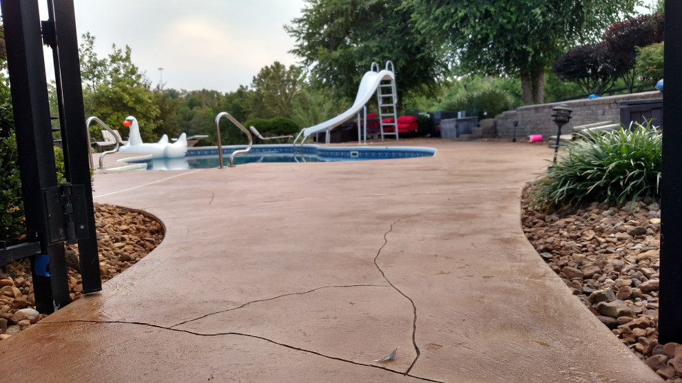 Example of a mountain style backyard stamped concrete and custom-shaped water slide design in Cincinnati