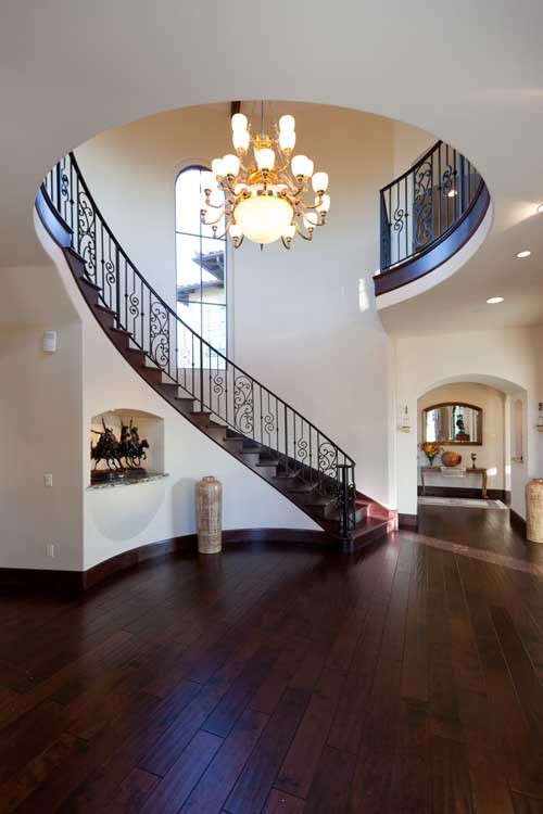 This is an example of a large mediterranean foyer in San Luis Obispo with beige walls and dark hardwood floors.