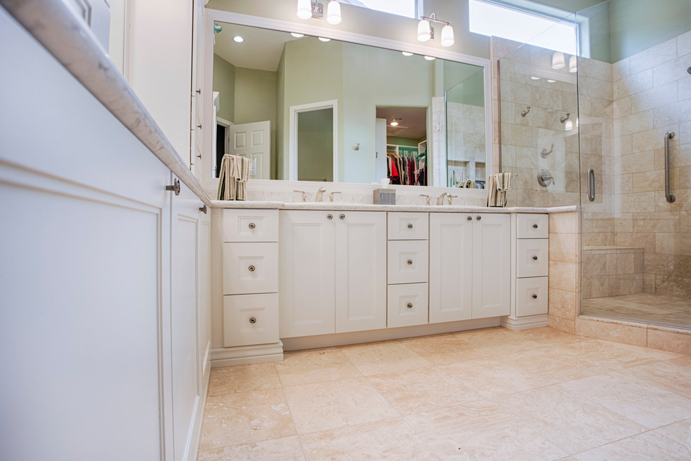 Example of a large transitional master beige tile and travertine tile travertine floor corner shower design in Phoenix with recessed-panel cabinets, white cabinets, green walls, an undermount sink and granite countertops