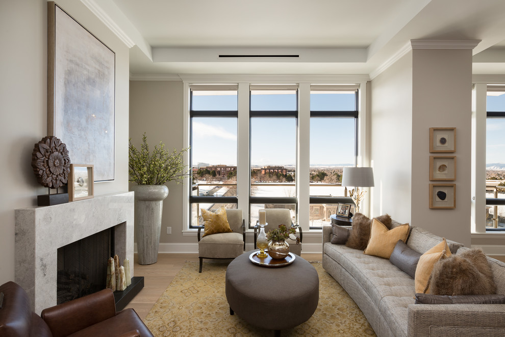 Transitional open concept living room in Denver with beige walls, a standard fireplace and light hardwood floors.