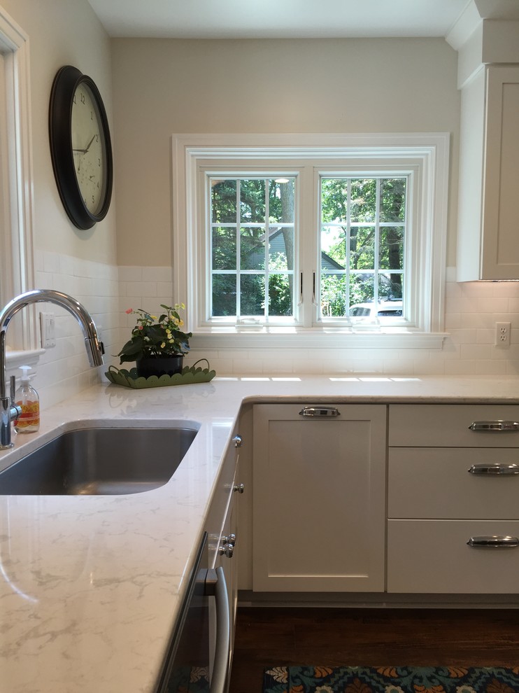 Mid-sized transitional u-shaped eat-in kitchen photo in Grand Rapids with flat-panel cabinets, white cabinets, quartz countertops, white backsplash, subway tile backsplash, stainless steel appliances, a peninsula and white countertops