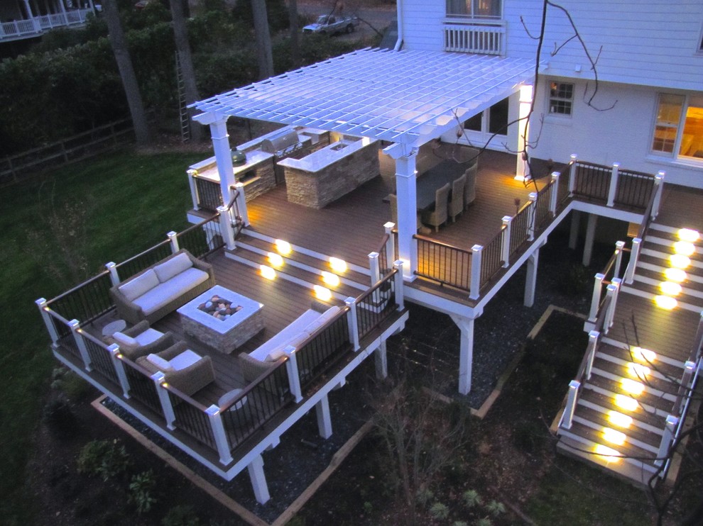 Photo of a large traditional backyard and first floor deck in DC Metro with an outdoor kitchen and a pergola.