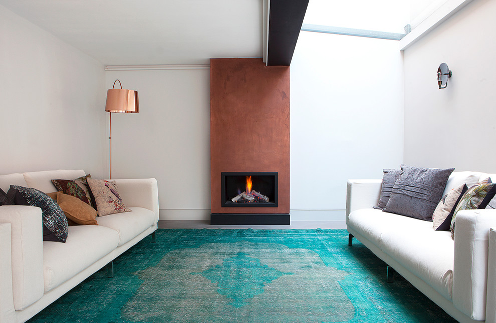 This is an example of a contemporary formal enclosed living room in London with white walls, carpet, a standard fireplace and turquoise floor.