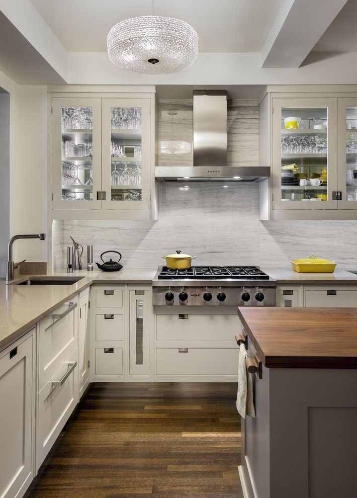 Photo of a transitional l-shaped kitchen in New York with an undermount sink, shaker cabinets, white cabinets, white splashback, stone slab splashback, stainless steel appliances, dark hardwood floors and with island.