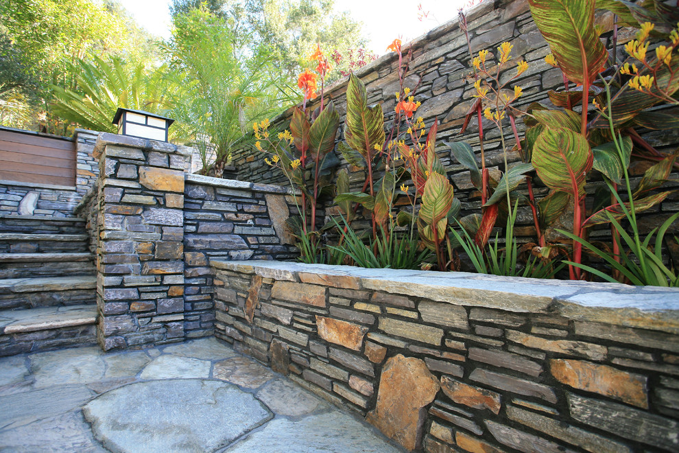 This is an example of a contemporary garden in Los Angeles with natural stone pavers.