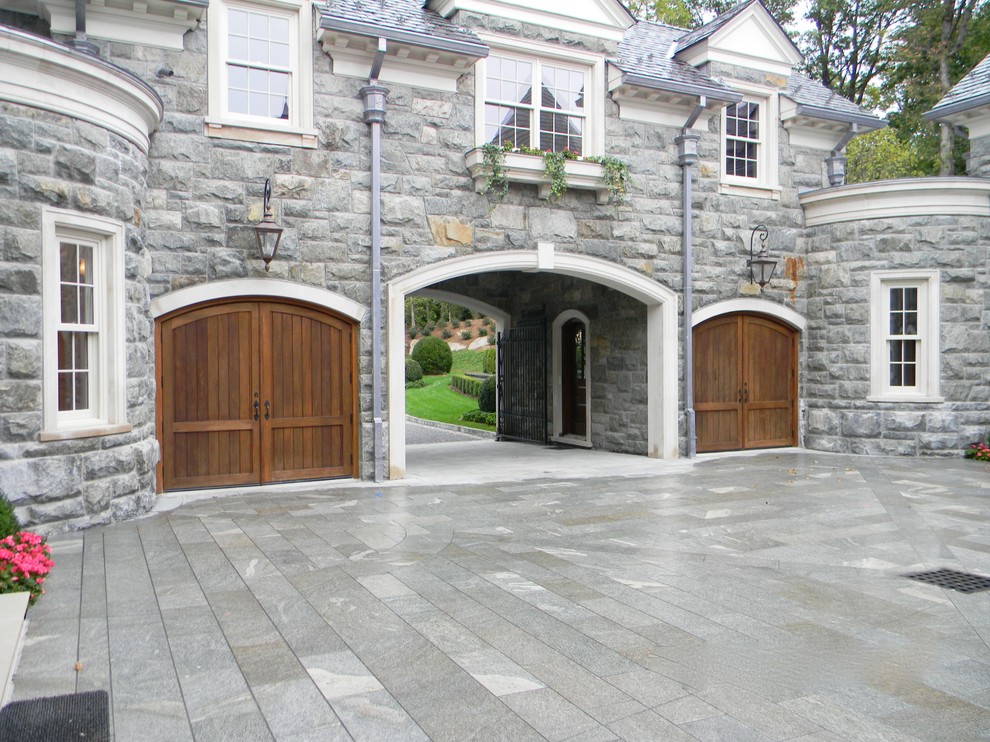 This is an example of a large arts and crafts attached two-car porte cochere in New York.
