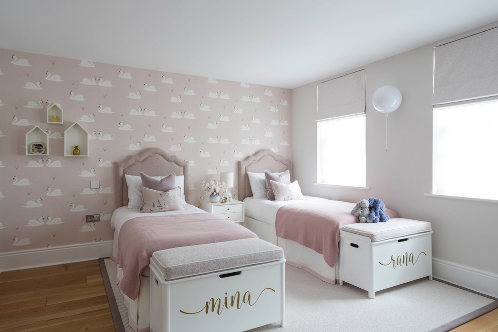 Design ideas for a transitional kids' bedroom for kids 4-10 years old and girls in Buckinghamshire with multi-coloured walls and medium hardwood floors.