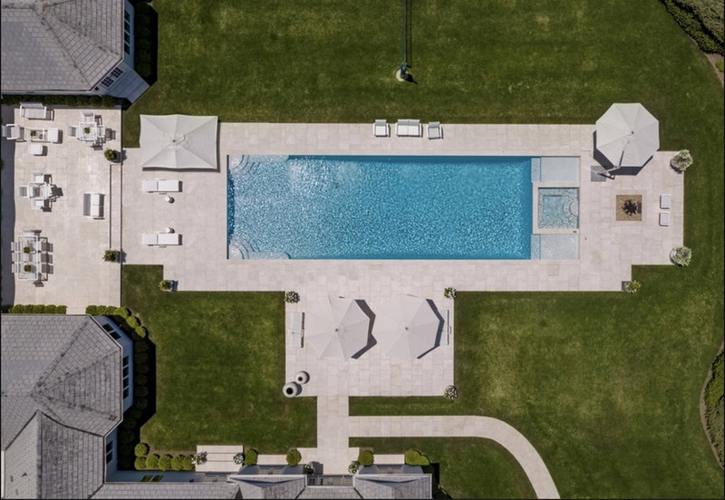 Example of a large backyard stone and rectangular lap hot tub design in New York