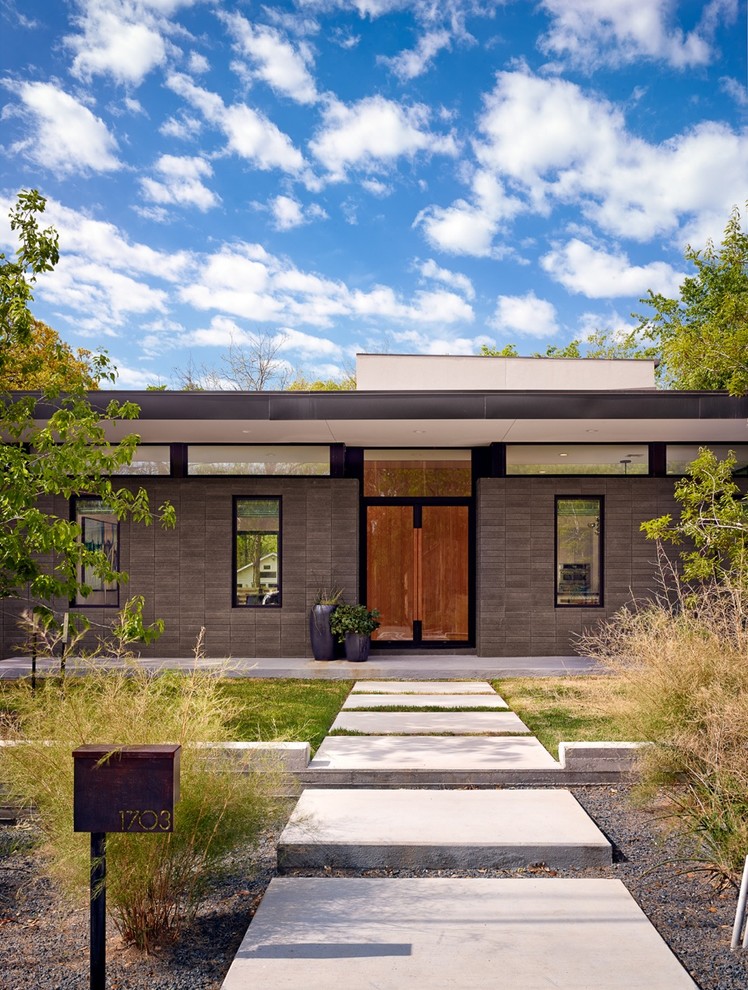 Modern two-storey brown exterior in Austin with a flat roof.