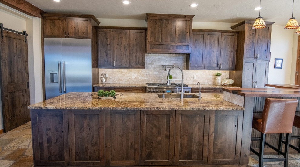 Photo of a large single-wall kitchen/diner in Denver with a submerged sink, shaker cabinets, dark wood cabinets, granite worktops, beige splashback, stone tiled splashback, stainless steel appliances, cement flooring, an island, grey floors and beige worktops.
